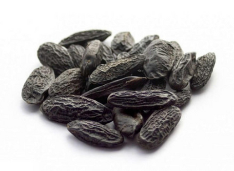 Close-up of dried Arabian Tonka beans on a white background.